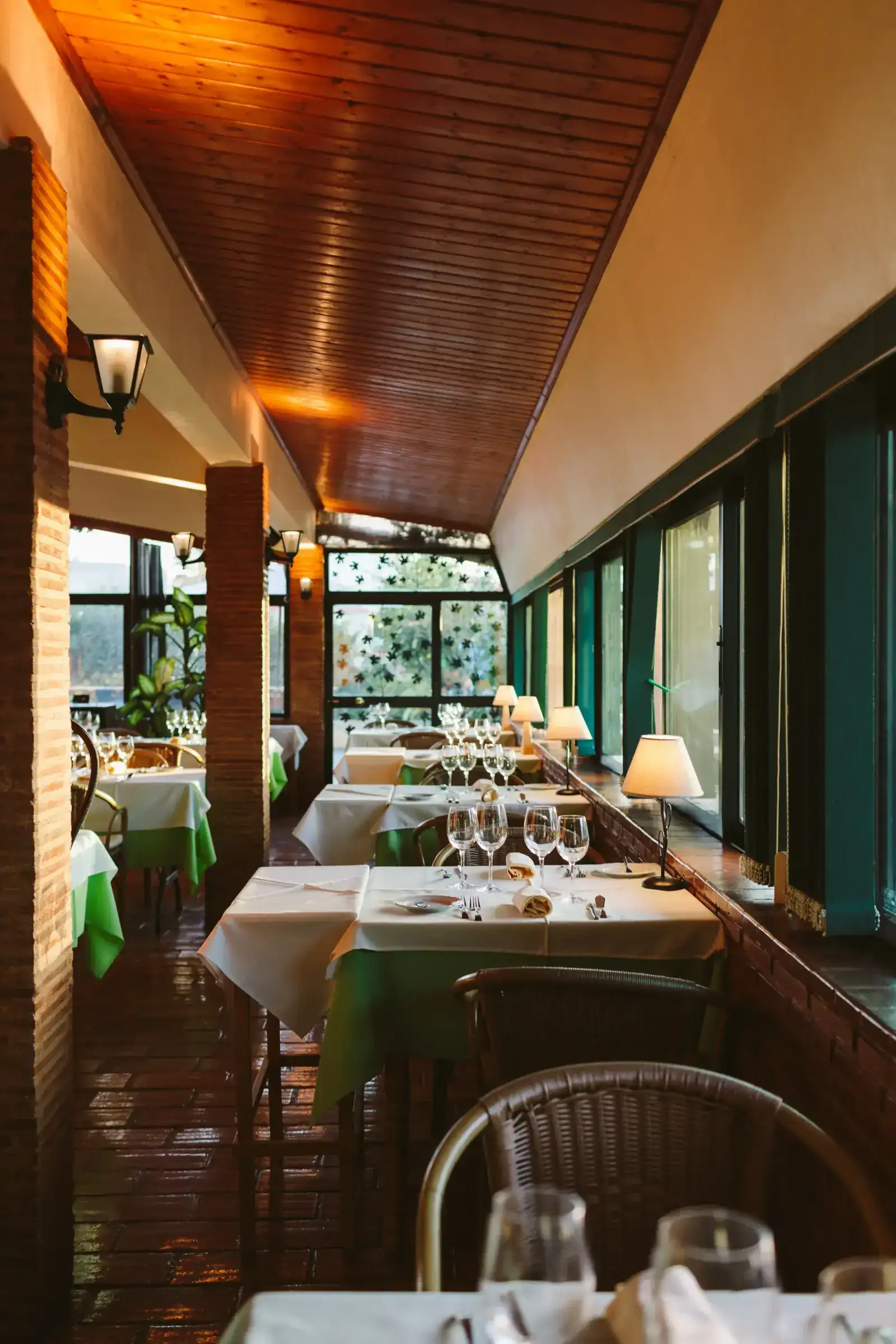 Luz quente sobre o salão: convívio prolongado no Restaurante Figueiral.